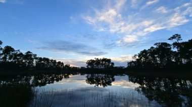 Time lapse of sunset cloudscape over Long Pine Key lake and campground in Everglades National Park, Florida 4K.