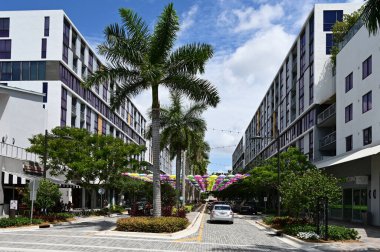 Doral, Florida - 9 Nisan 2023 - Ziyaretçiler güneşli Pazar sabahı Doral CityPlace Bulvarı üzerinde asılı renkli şemsiyelerin keyfini çıkarıyorlar.