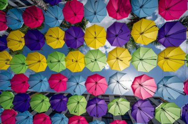 Doral, Florida - 9 Nisan 2023 Doral CityPlace Bulvarı üzerinde güneşli Pazar sabahı asılı renkli şemsiyeler.