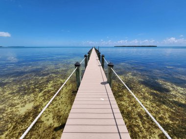 Tavernier, Florida - 2 Nisan 2023 - Uzun liman güneşli öğleden sonra Tavernier Key 'deki berrak sulara uzanır.