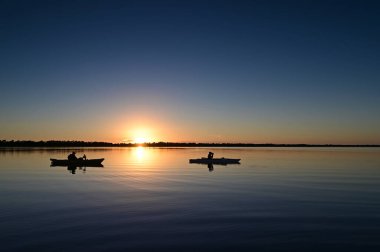 Florida Everglades Ulusal Parkı 'ndaki Coot Körfezi' nin sakin sularında gün batımında iki kanocu..