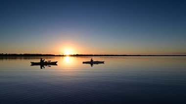 Florida Everglades Ulusal Parkı 'ndaki Coot Körfezi' nin sakin sularında gün batımında iki kanocu..