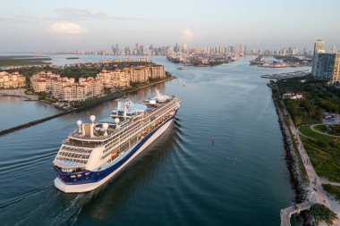 Miami Beach, Florida - 22 Temmuz 2023 - Miami Limanı 'na gün doğumunda Miami Limanı' na giriş yapan yolcu gemisi, arka planda Fisher Adası, South Pointe Park ve Miami silueti ile birlikte.