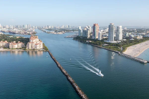 Aerial view of Fisher Island, Miami Beach, Port Miami and Miami skyline at sunrise on clear calm summer morning..