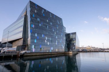 Reykjavik, İzlanda - 4 Eylül 2023 - Harpa Konser Salonu güneşli bir sonbahar sabahı Reykjavik Limanı 'nın sakin sularına yansıdı.