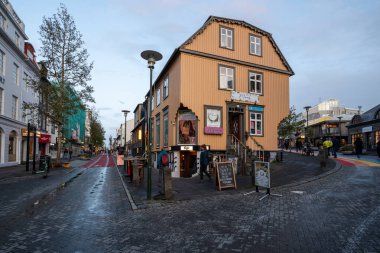 Reykjavik, İzlanda - 3 Eylül 2023 - Sonbahar bulutları altında karakteristik kıvrımlı demir bina yapısını gösteren renkli sokak sahnesi.