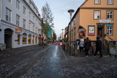 Reykjavik, İzlanda - 3 Eylül 2023 - Güneşli sonbahar alacakaranlık bulutları altında sokak sahnesi.