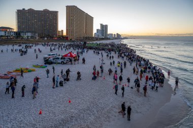 Panama City Beach, Florida - November 4, 2023 - Crowd of spectators and athletes on beach at start of 2023 Ironman competition. clipart