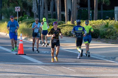 Panama City Beach, Florida - 4 Kasım 2023 - Genç kadın 2023 Ironman yarışmasının maraton bölümünde koşuyor.