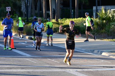 Panama City Beach, Florida - 4 Kasım 2023 - Genç kadın 2023 Ironman yarışmasının maraton bölümünde koşuyor.