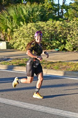 Panama City Beach, Florida - 4 Kasım 2023 - Genç kadın 2023 Ironman yarışmasının maraton bölümünde koşuyor.