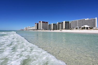 Beyaz kum plajı, kristal berrak su ve güneşsiz sonbahar gününde Panama City Beach, Florida 'nın sahil binaları..
