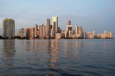 Miami, Florida - 12-27-2023 - Günbatımında Biscayne Körfezi 'nin sakin sularına yansıyan şehir silüeti.