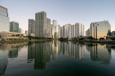Miami, Florida silueti, bulutsuz bir Aralık sabahı gün doğumunda Biscayne Körfezi 'nin sakin sularına yansıdı..