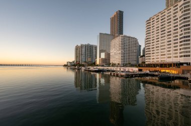 Miami, Florida silueti, bulutsuz bir Aralık sabahı gün doğumunda Biscayne Körfezi 'nin sakin sularına yansıdı..