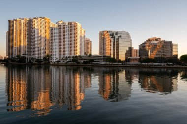 Miami, Florida silueti, bulutsuz bir Aralık sabahı gün doğumunda Biscayne Körfezi 'nin sakin sularına yansıdı..