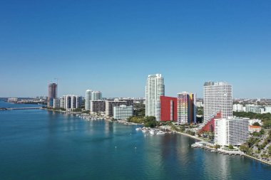 Aerial image of waterfront residential buildings in Brickell neighborhood of Miami, Florida reflected in calm water of Biscayne Bay on sunny morning. clipart