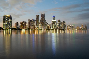 Miami, Florida - 30 Ocak 2024 - Alacakaranlıkta şehir silüeti Biscayne Körfezi 'nin sakin sularına yansıdı.
