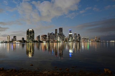 Miami, Florida - 30 Ocak 2024 - Alacakaranlıkta şehir silüeti Biscayne Körfezi 'nin sakin sularına yansıdı.
