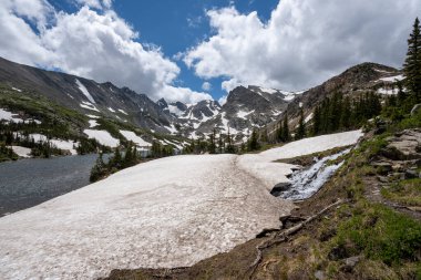 Güneşli yaz bulutları altında Colorado 'daki Indian Peaks Wilderness' da Isabelle Gölü 'ndeki eriyen buzullar.