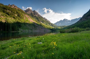 Güneşli bir öğleden sonra, dramatik bir yaz bulutu altında Maroon Gölü 'nün etrafında Maroon Bells manzaralı yürüyüş..