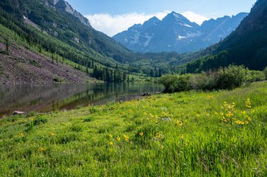 Güneşli bir öğleden sonra, dramatik bir yaz bulutu altında Maroon Gölü 'nün etrafında Maroon Bells manzaralı yürüyüş..