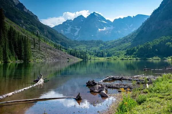 stock image Maroon Bells reflected in Maroon Lake on sunny summer afternoon under dramatic summer cloudscape.