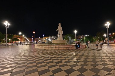 Nice, Fransa - 20 Eylül 2024: Cuma gecesi Massena Plaza 'da Fontaine du Soleil' in tadını çıkaran gençler grubu.