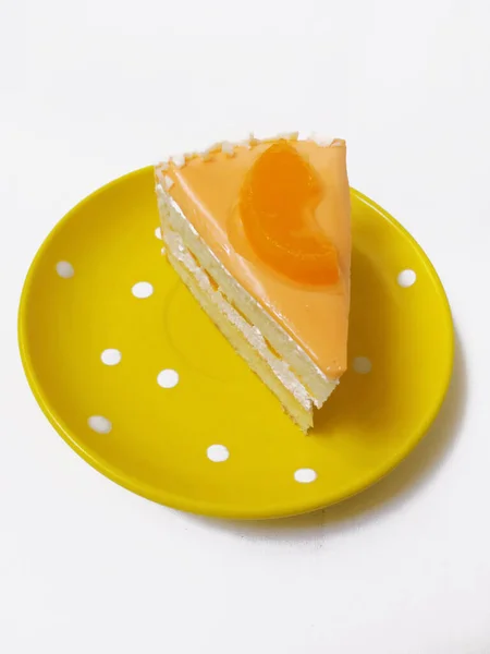 Ein Stück Kuchen Auf Einem Gelben Teller Auf Weißem Hintergrund — Stockfoto