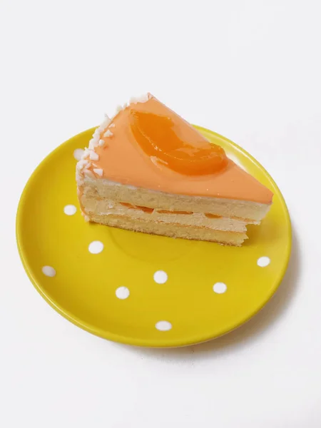 a piece of cake on a yellow plate on a white background