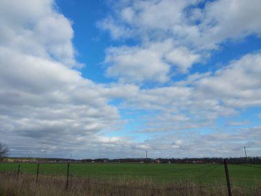 Bir köyün üzerinde çok renkli bulutlar uçuşuyor.