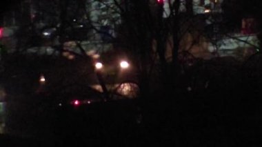 Şehrin şehir kavşağında arabalar sürülüyor.