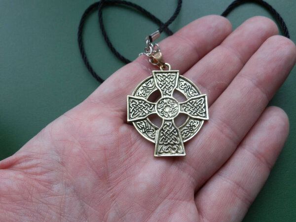 Медальон религиозного металла в руке