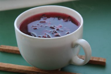 Sudan gülü amber çiçeği çayı yaprakları bir bardakta, tezgahın üstünde.