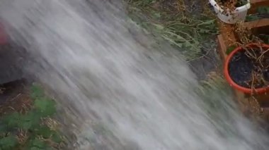 Bir yangın musluğundan sokağa su dökülüyor.