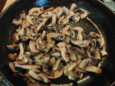 Kızartma tavasında kızartılmış şampiyon mantarları.