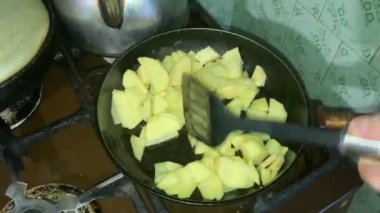 Patatesler kızartma tavasında kızarır ve karıştırılır.