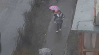 KYIV, UKRAINE - 18 Mart 2024: İnsanlar yağmurda şemsiye altında sokakta yürüyorlar