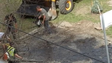 KYIV, UKRAINE - 1 Nisan 2024: Ekipmanlı işçiler tarafından asfalt döşeme