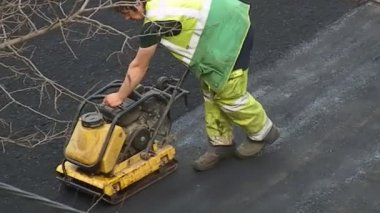 KYIV, UKRAINE - 1 Nisan 2024: Bölgede taze asfalt sıkıştırılıyor