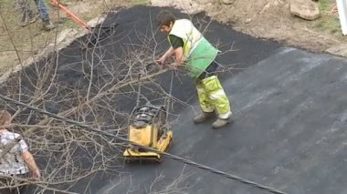 KYIV, UKRAINE - 1 Nisan 2024: Bölgede taze asfalt sıkıştırılıyor