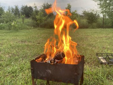 Barbekü ızgarasında odun yanıyor.