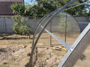 Metal çerçeveli polikarbonat kaplı bir sera kurulumu