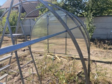 Metal çerçeveli polikarbonat kaplı bir sera kurulumu