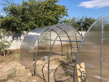 Metal çerçeveli polikarbonat kaplı bir sera kurulumu
