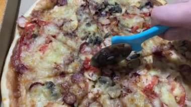 Yuvarlak bıçakla pizza dilimleri kesmek.