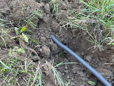 Bir seraya elektrik kablosu kurma sürecini yakalayan bir görüntü, aydınlatma, ısıtma ve ekipman için güç sağlıyor.