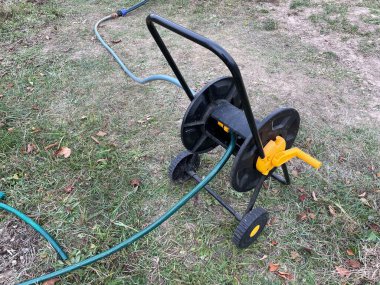 Bahçe hortumu canlı bir sebze bahçesini sular. Büyüyen bitkilerin sıralarına gerekli suyu sağlar. Bu görüntü, sağlıklı ve verimli bir bahçe yetiştirmeye yarayan araçları ve özeni yakalar.