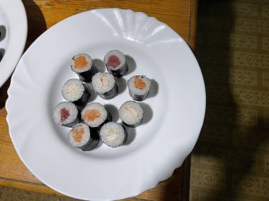 Taze balıkların, sirkeli pirincin ve çeşitli garnitürlerin yer aldığı güzel düzenlenmiş bir suşi seti..