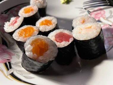 Taze balıkların, sirkeli pirincin ve çeşitli garnitürlerin yer aldığı güzel düzenlenmiş bir suşi seti..